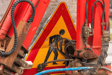 Damaged road works traffic sign and industrial equipment, selective focusの写真素材