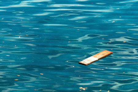 Wooden plank floating on ocean water surface after storm