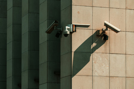 Old worn surveillance security cameras mounted on building wall, selective focusの写真素材