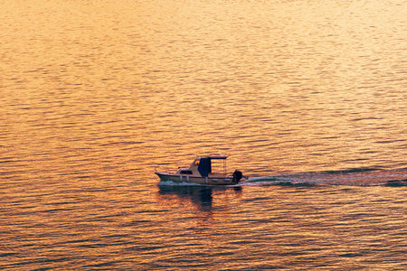 Fishing boat dinghy at sea in sunset, selective focus