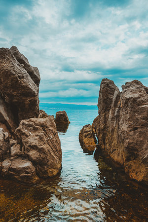 Kvarner gulf of Adriatic sea rocky coastline, large rocks at shoreline in old town of Lovran in Croatia. Selective focus.の写真素材