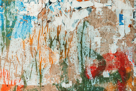 Textured surface of torn poster paper on concrete wall as grunge texture and background. Messy and grimy pattern.の写真素材
