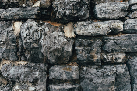 Old gray stone wall as background, texture of a worn facade from Opatija, Croatia.