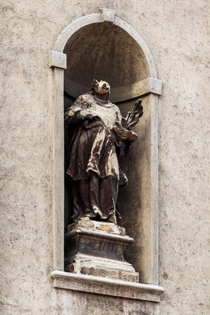 Worn and damaged statue at catholic church facade, detail of christianity architectureの写真素材