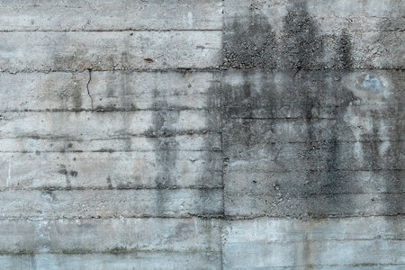 Rough concrete wall surface as grunge background, worn industrial facadeの写真素材