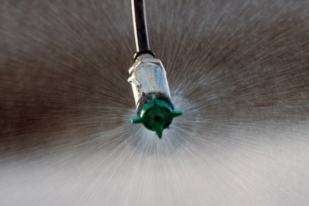 Closeup of agricultural sprinkler head spraying water drops at field, selective focusの写真素材