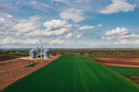 Farm silos in field, aerial view from drone pov on sunny spring dayの写真素材
