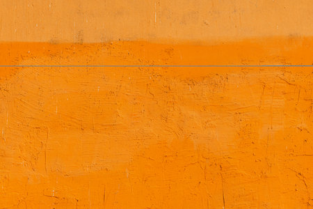 Rough yellow plaster wall as grunge texture and backgroundの写真素材