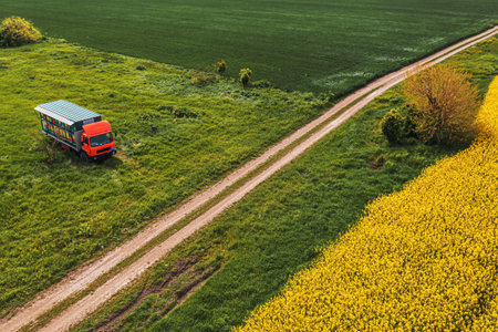 Aerial shot of apiary truck with colorful beehive wooden crates in trailer, drone povの写真素材
