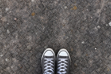 Top view of sneakers on concrete surface, Young man standing on the street. Copy space included.の写真素材