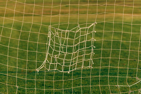 Old patched soccer goal net as abstract sport background and patternの写真素材