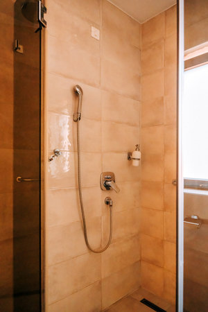 Bathroom shower cabin with glass panel, vertical image with selective focusの写真素材