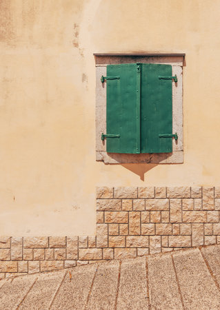 Green window with metallic shutters, typical architectural style at Adriatic seaside, copy space includedの写真素材