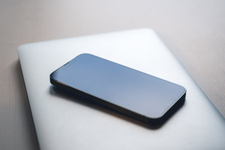 Smartphone and laptop computer on office desk, modern technology equipment necessary for business, selective focusの写真素材