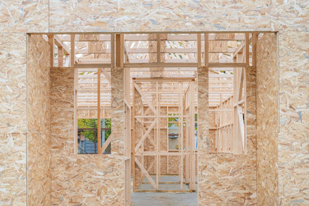 Prefabricated wooden house construction site, wood beam joists and wood chip boards, selective focus