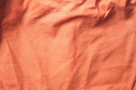 Texture of old crumpled textile material in peach fuzz color, top viewの写真素材