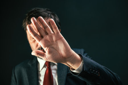 Crooked politician covering face and hiding from paparazzi photographer, selective focusの写真素材
