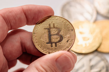 Man holding physical Bitcoin, cryptocurrency trading financial activity concept, selective focus