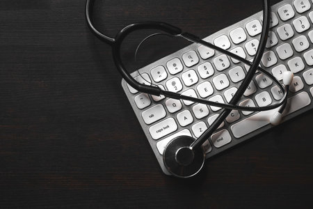 Stethoscope and computer keyboard on doctor's desk, high angle viewの写真素材