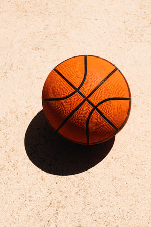 Used basketball ball on concrete surface of outdoor court in summer