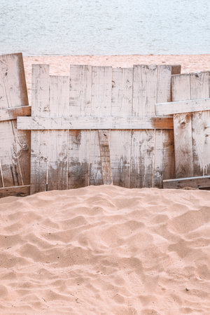 Wooden plank fencing on Danube river sandy beach, vertical image with selective focusの写真素材