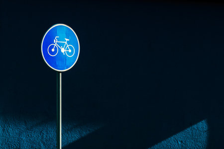 Bicycle lane traffic sign on the street against the dark blue wall as copy spaceの写真素材