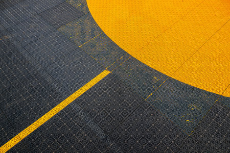 Non slip plastic surface of an outdoor basketball court with yellow marking line