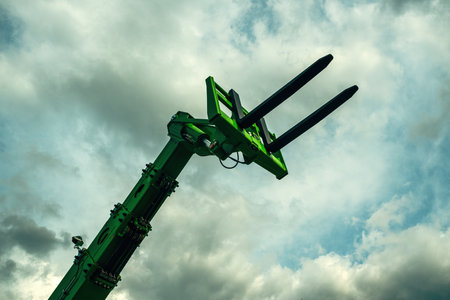 Forklift forks, industrial machinery and equipment against dramatic sky, low angle view
