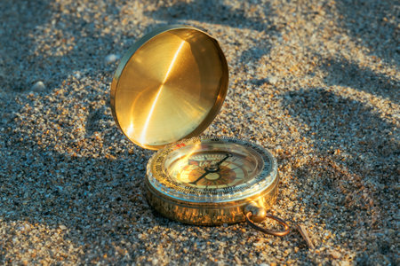 Compass in the sand, vintage navigational equipment on the beach, selective focusの写真素材