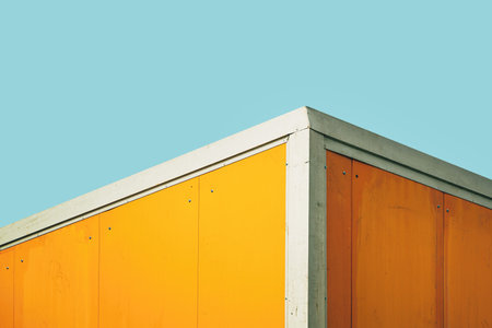 Yellow industrial warehouse container against blue sky, minimalistic compositionの写真素材