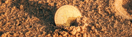 Bitcoin cryptocurrency golden coin in beach sand, selective focusの写真素材