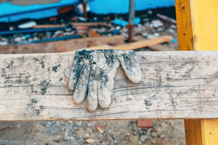 Old worn protective work glove on construction site, selective focusの写真素材