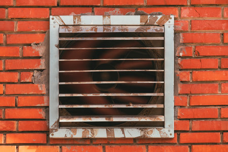 Industrial ventilation fan in operation on a pig farm with brick wallの写真素材