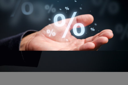 Interest rate, dividend and discount concept. Closeup of male hand with percent symbol. Selective focusの写真素材