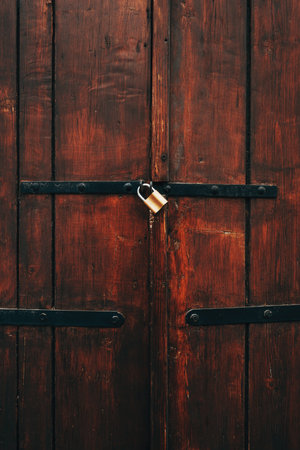 Old wooden gate locked with padlock, vertical imageの写真素材