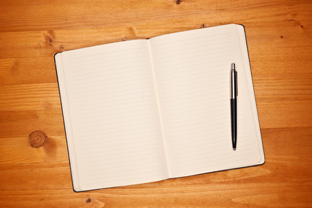 Notebook on office desk, open diary with blank white pages for text mockup, top view