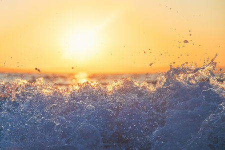 Ocean wave at summer sunrise, beautiful sunlight and sea foam, selective focus