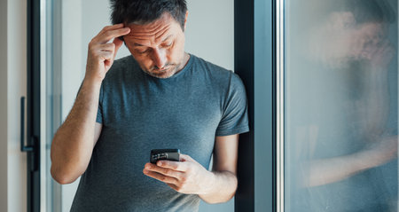 Reading worrying text message on mobile phone, selective focus