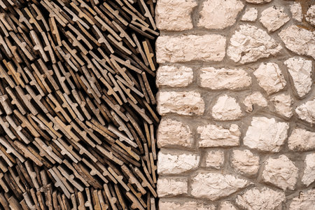 Pattern of old worn roof tiles stacked next to a stone wallの写真素材