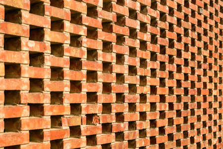 Perforated brick wall with geometric pattern and urban design. Selective focus.