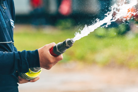 Firefighter spraying water from the hose, selective focus