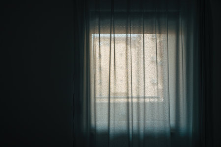 Bright light coming from the living room window through white curtains, selective focusの写真素材