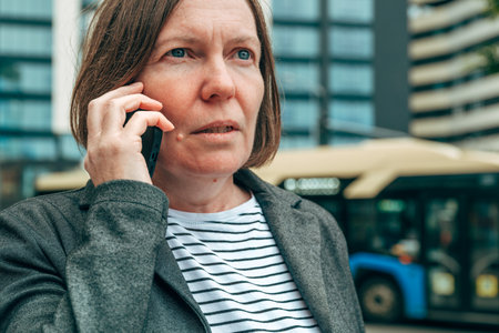 Businesswoman using mobile phone, talking on smartphone on downtown city street, selective focusの写真素材