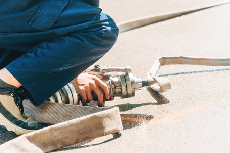 Firefighters attaching water hose on site, selective focusの写真素材