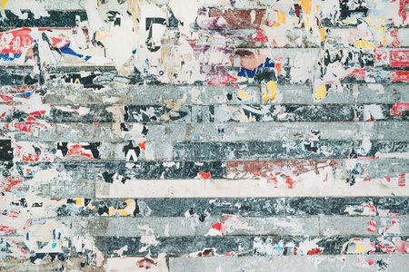 Torn poster paper pattern background, grunge texture of shredded ad billboards on the wallの写真素材