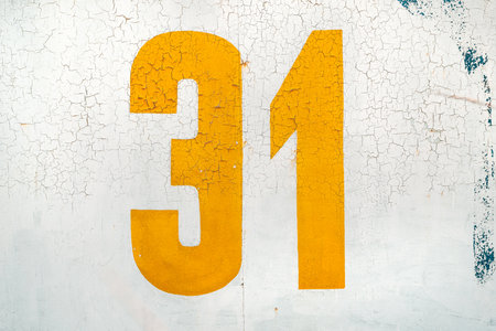 Yellow number thirty one on grunge white wall as backgroundの写真素材