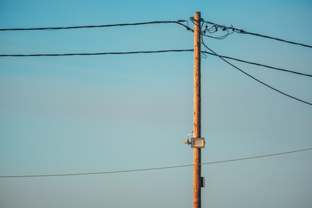 Wooden electricity post with LED light against blue sky, selective focusの写真素材
