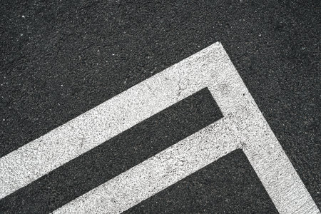 Road marking white lines on asphalt surface as abstract pattern, top view