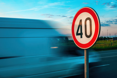 Van speeding by the speed limit traffic sign, motion blur image with selective focus