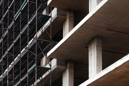 Low angle view of modern corporate office building construction site, concrete frame structure with...